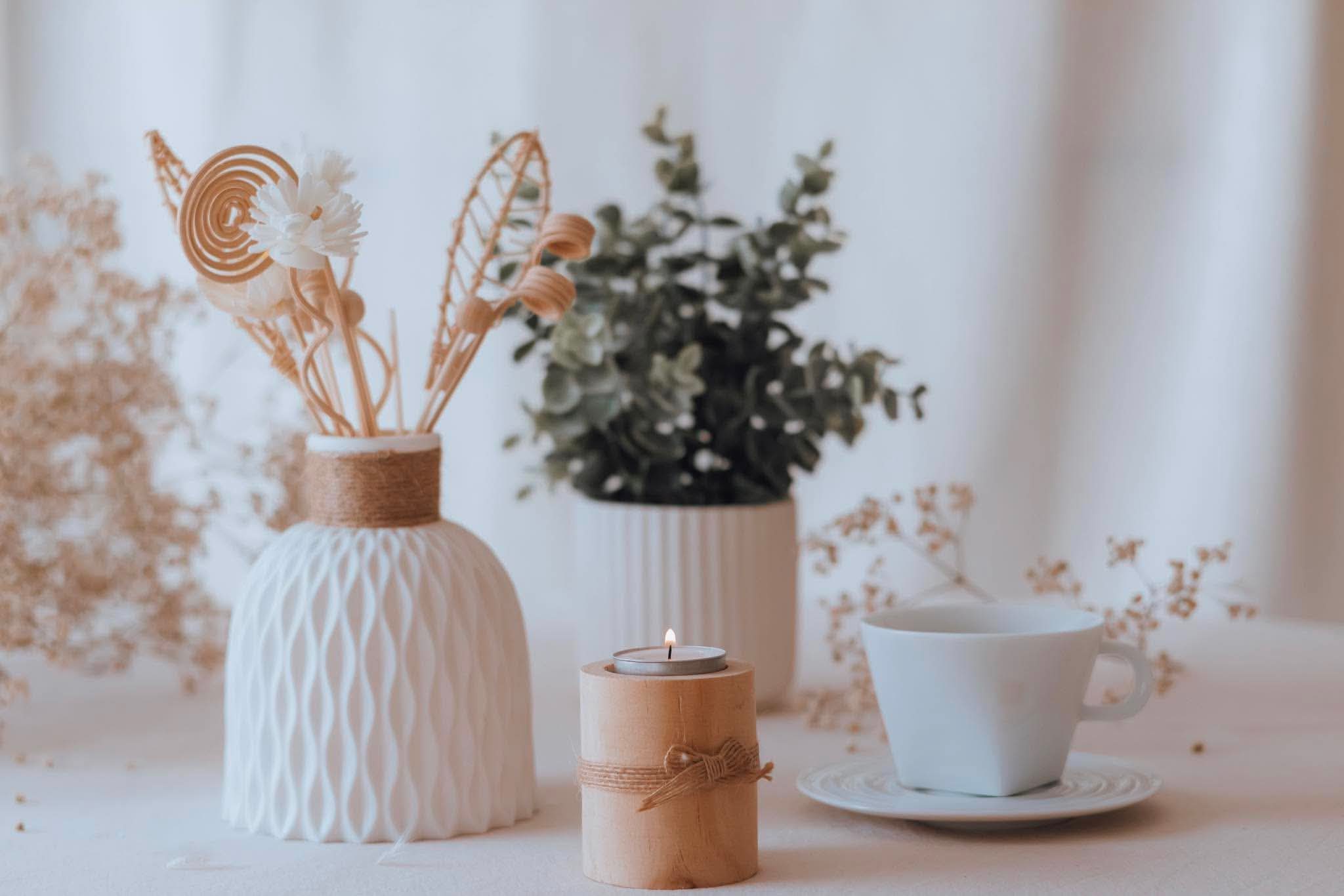 Ambiance douce d'accueil : vase, bougie et tasse — Entre Deux