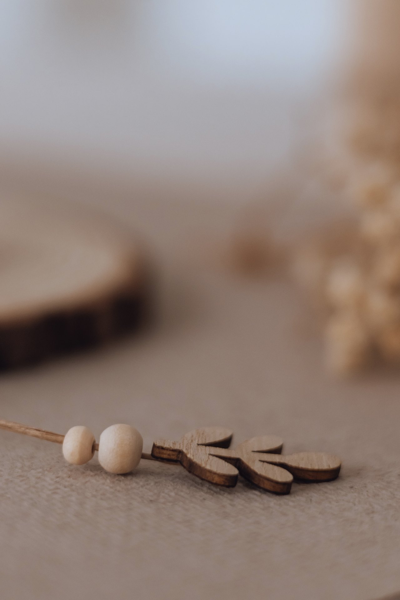 Perles de bois et petites feuilles à enfiler, posées près du rondin de l'arbre des valeurs — Entre Deux