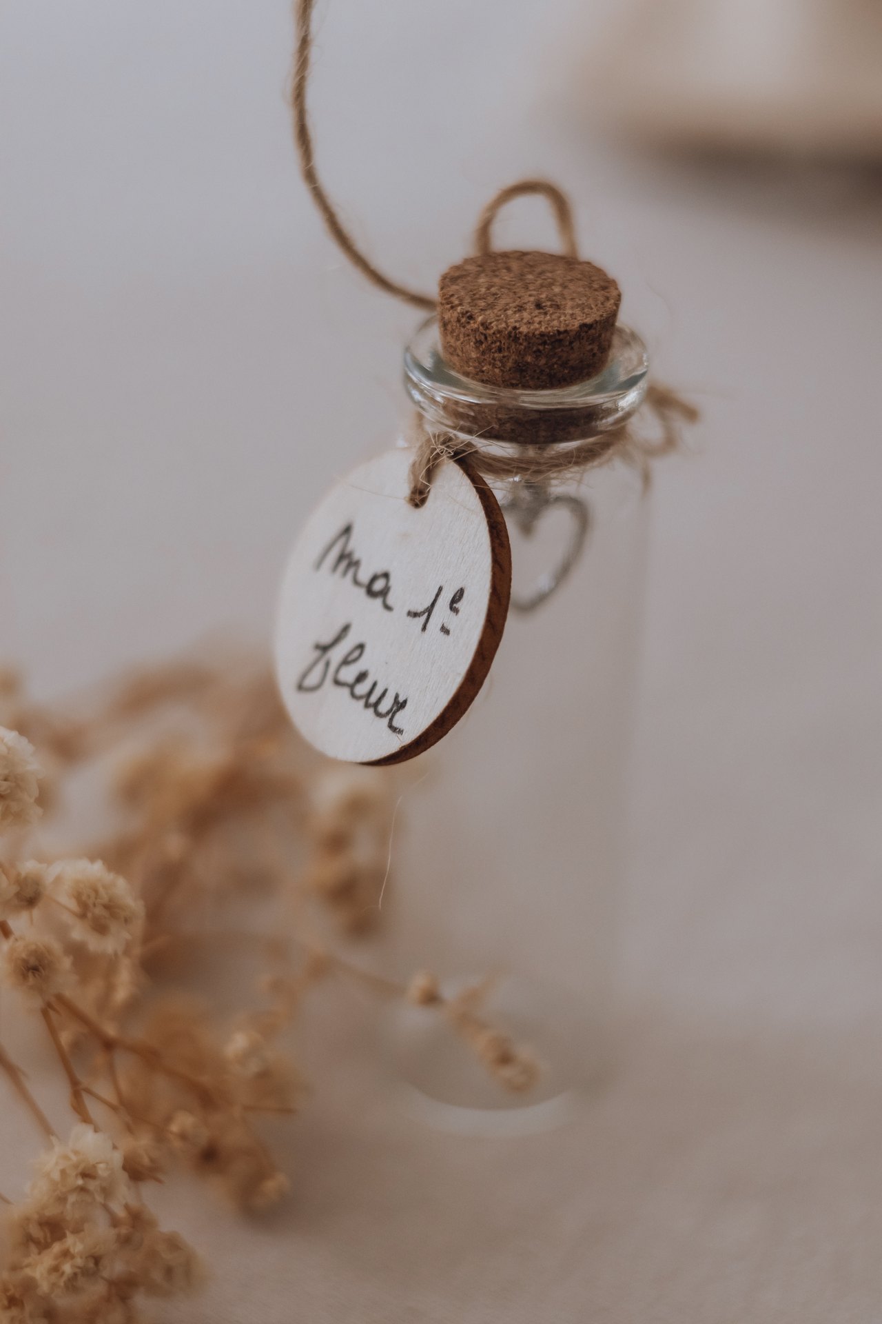 Petite fiole de verre bouchée de liège, étiquetée « ma 1re fleur », pour garder une trace dans le coffret — Entre Deux