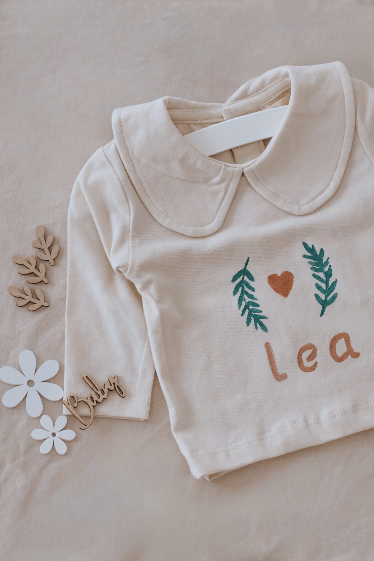 Blouse de bébé personnalisée avec le prénom Léa et des feuillages peints
