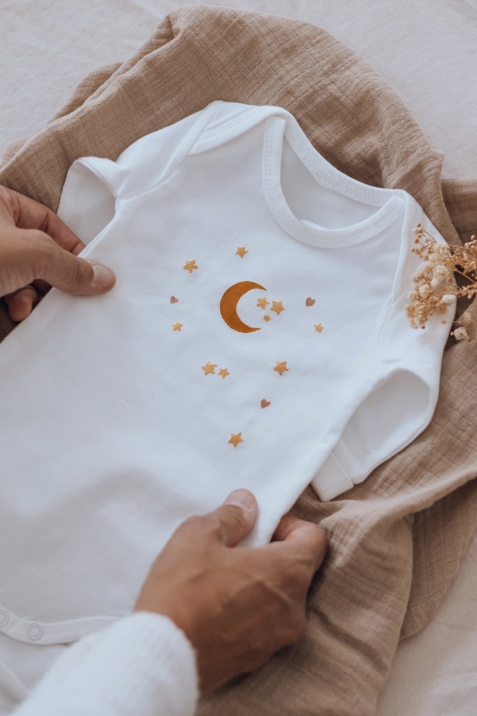 Vêtement à la lune et aux étoiles dorées, terminé et lissé à la main sur un lange de coton